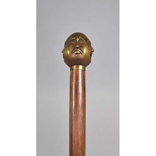 131 - A Modern Turned Wooden Walking Cane with Bronze Four Sided Buddha Handle