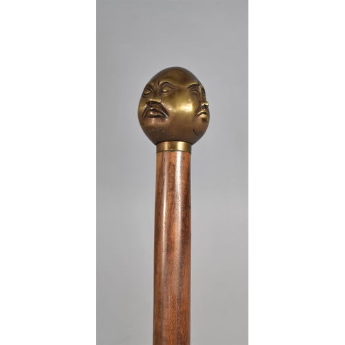 131 - A Modern Turned Wooden Walking Cane with Bronze Four Sided Buddha Handle