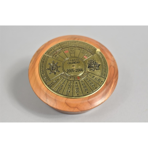 26 - A Brass 40 Year Calendar, 2005-2044, Mounted on Turned Yew wood Stand, 8.25cms Diameter