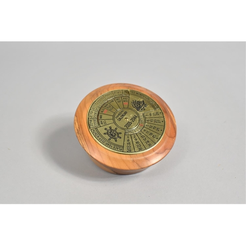 26 - A Brass 40 Year Calendar, 2005-2044, Mounted on Turned Yew wood Stand, 8.25cms Diameter