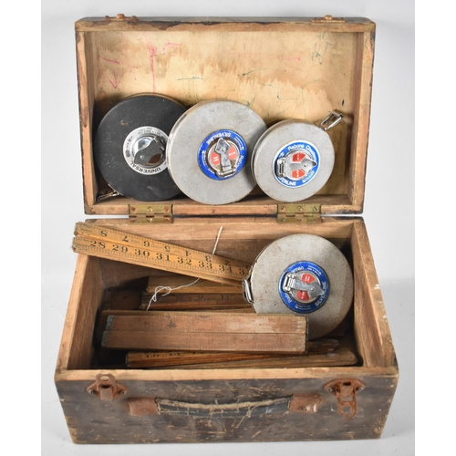 61 - A Vintage Wooden Tool Box Containing Folding Rulers and Metal Tape Measures