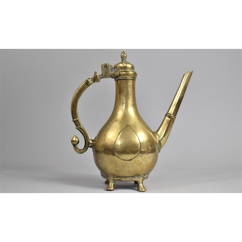 65 - A 19th Century Islamic Brass Ewer with Hinged lid on Four Feet, Scrolled Handle, 25cms High