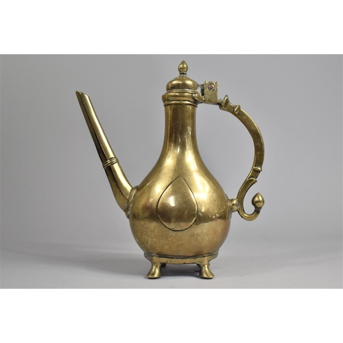 65 - A 19th Century Islamic Brass Ewer with Hinged lid on Four Feet, Scrolled Handle, 25cms High