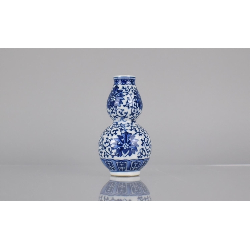 15 - A Chinese Blue and White Porcelain Double Gourd Vase Decorated in a Floral Motif, Blue Seal Mark to ... 