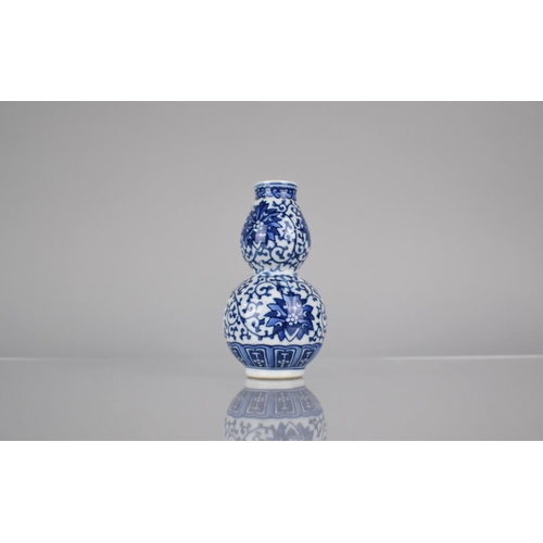 15 - A Chinese Blue and White Porcelain Double Gourd Vase Decorated in a Floral Motif, Blue Seal Mark to ... 