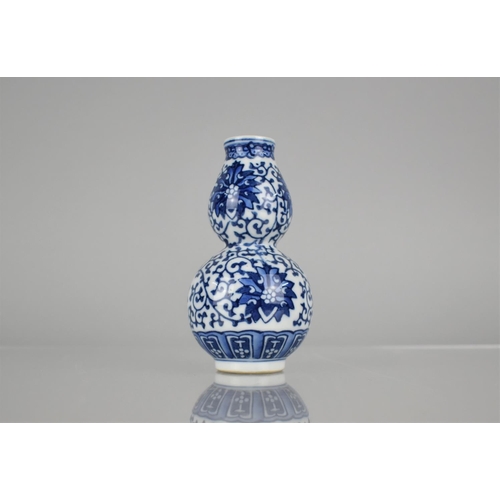 15 - A Chinese Blue and White Porcelain Double Gourd Vase Decorated in a Floral Motif, Blue Seal Mark to ... 