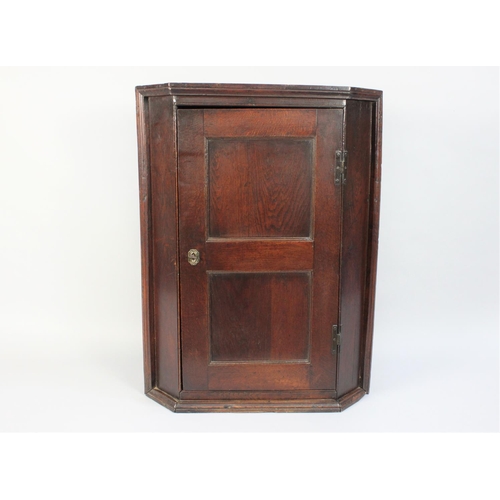 365 - An 18th Century Oak Corner Cupboard with a Twin Panelled Door and Original Brass Hinges. 68cms Wide ... 