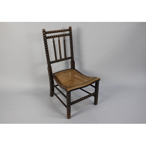 369 - A 19th Century Slipper Chair with Bobbin Turned Back over a Caned Seat, 80cms High