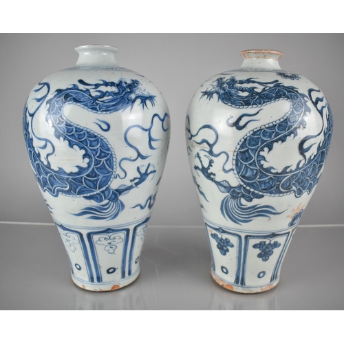 408 - A pair of Blue and White Vases decorated with Dragons Amongst Scrolls and Clouds, 30cms High