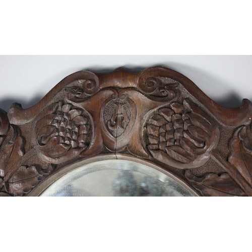 433 - A Carved Oak Wall Mirror in the Manner of Arthur Simpson, Kendal with Oval Bevelled Glass, 68x88cms