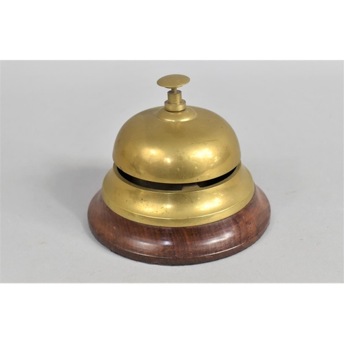 19 - A Modern Brass Countertop Reception Bell on Turned Wooden Plinth, 11cms Diameter