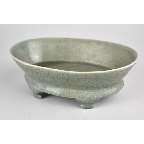 242 - A Reproduction Celadon Oval Dish Raised on Four Scrolled Feet, 19cm wide