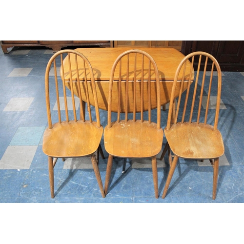 490 - A 1970's Drop Leaf Dining Table Together with Three Hooped Back Chairs in the Windsor Style