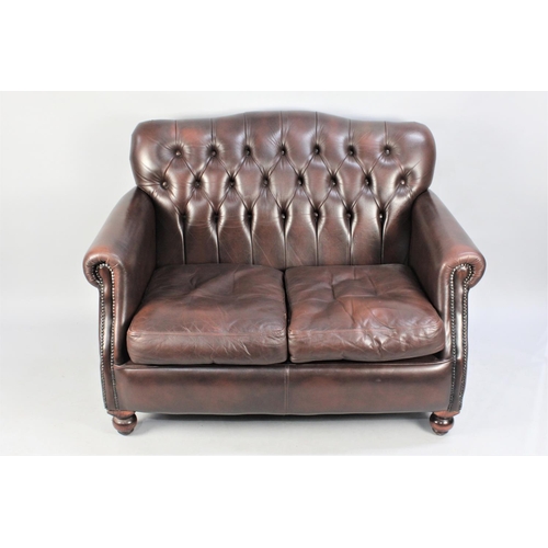 513 - A Button Back Chesterfield Style Two Seater Sofa in Brown Leather Effect, 120cm wide