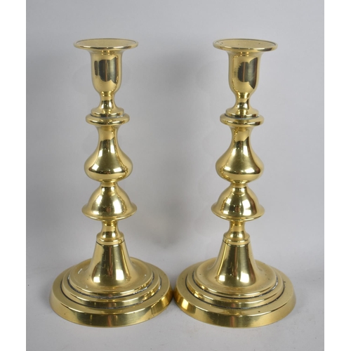 82 - A Pair of Victorian Polished Brass Candlesticks with Pushers, 23.5cms High