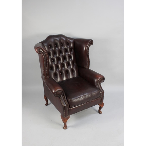 422 - A Leather Effect Buttoned Back Wing Armchair