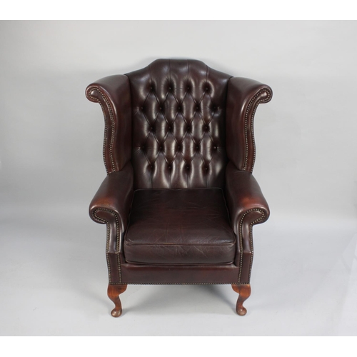 422 - A Leather Effect Buttoned Back Wing Armchair