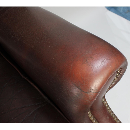 422 - A Leather Effect Buttoned Back Wing Armchair