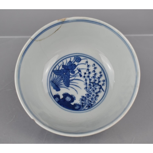 253 - A Chinese Porcelain Blue and White Bowl decorated with River Village Scene and Central Bird in Branc... 