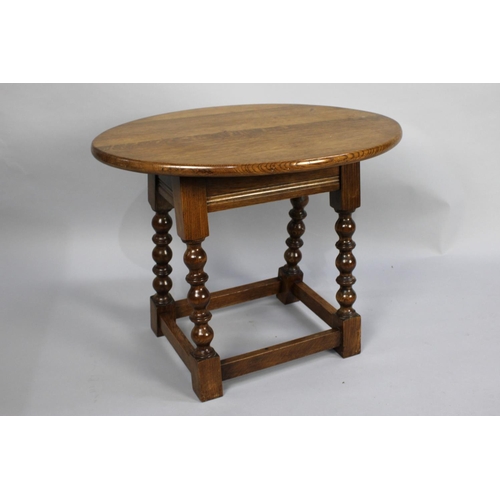 469 - An Edwardian Oak Oval Topped Occasional Table with Bobbin Supports, 60cms wide