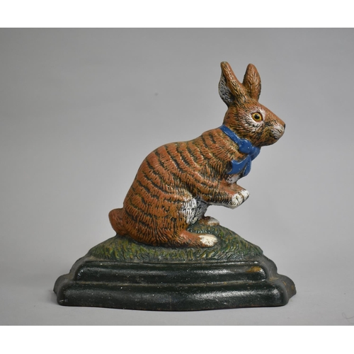 62 - A Modern Cast Iron Cold Painted Door Stop in the Form of a Seated Rabbit with Ribbon, 20cms High