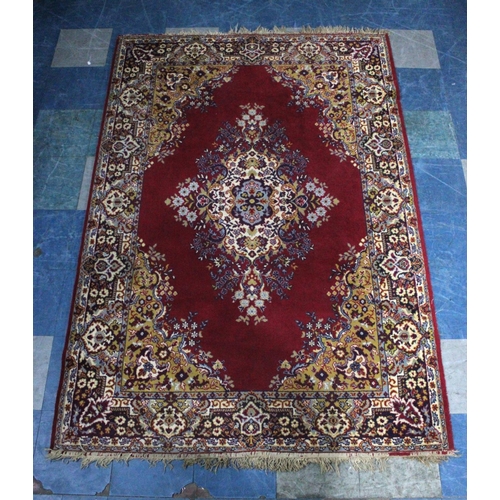 505 - A Mid 20th Century Patterned Rug on Red Ground, 220x150cms