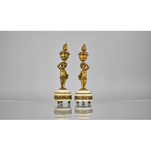 97 - A Pair of French Gilt Bronze and Marble Candlesticks Modelled as Cherubs Supporting Urns having Flam... 