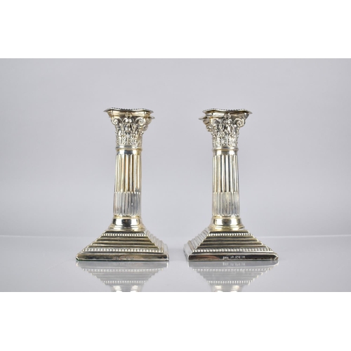 143 - A Pair of Edward VII Silver Corinthian Column Candlesticks by Barker Brothers on Stepped Square Plin... 