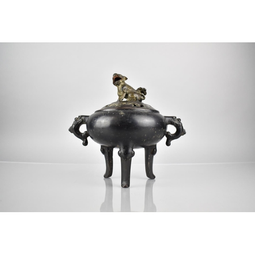 353 - A Chinese Patinated Bronze Tripod Censer and Cover, the Squat Belly with Twin Zoomorphic Handles and... 