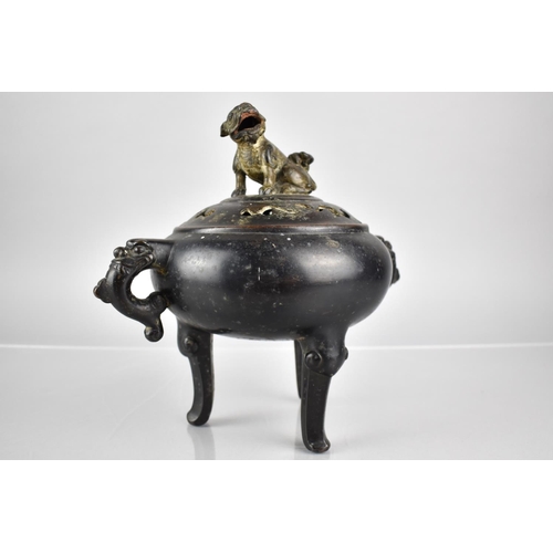 353 - A Chinese Patinated Bronze Tripod Censer and Cover, the Squat Belly with Twin Zoomorphic Handles and... 