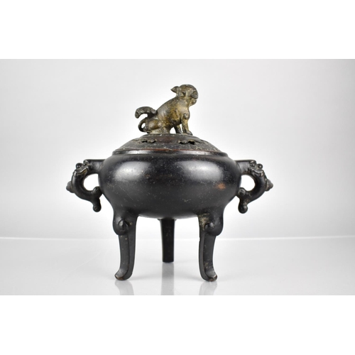 353 - A Chinese Patinated Bronze Tripod Censer and Cover, the Squat Belly with Twin Zoomorphic Handles and... 