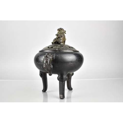 353 - A Chinese Patinated Bronze Tripod Censer and Cover, the Squat Belly with Twin Zoomorphic Handles and... 