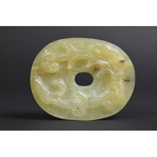 341 - A Chinese Green Hardstone Roundel with Floral Relief Carving, 7cm Wide.