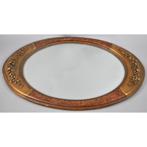 212 - A Modern Wall Hanging Oval Wall Mirror with Relief Floral Swag Decoration, 53cms by 35cms