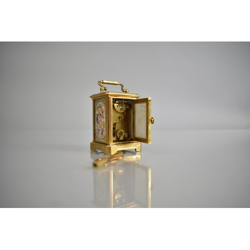 444 - A Reproduction Miniature Gilt and Porcelain Panel Carriage Clock in the Sevres Style with Key and Wo... 