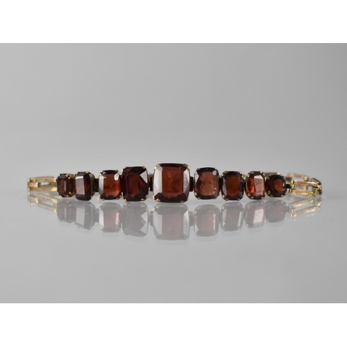 14 - An Early 20th Century Gold Coloured Metal Bracelet Mounted with Nine Graduated Emerald/Cushion Cut G... 