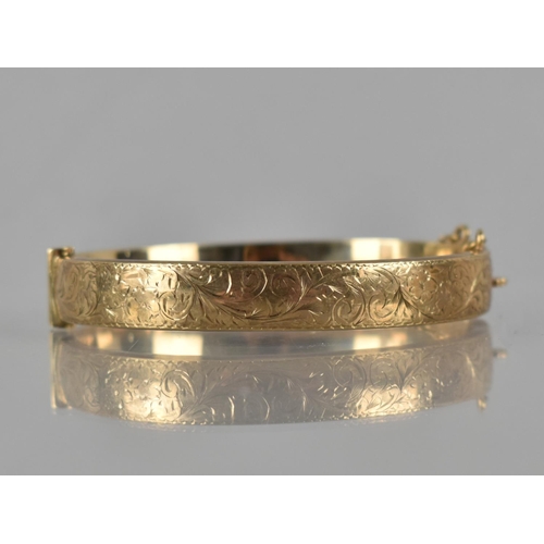 111 - A 9ct Gold Hinged Bangle, Front Plaque Engraved with Scrolling Decoration, Marked for Birmingham 199... 