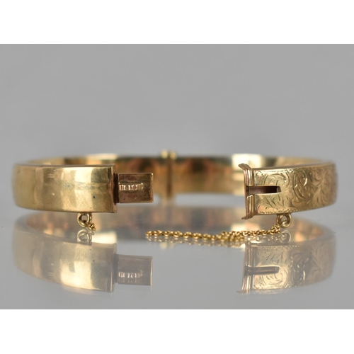 111 - A 9ct Gold Hinged Bangle, Front Plaque Engraved with Scrolling Decoration, Marked for Birmingham 199... 