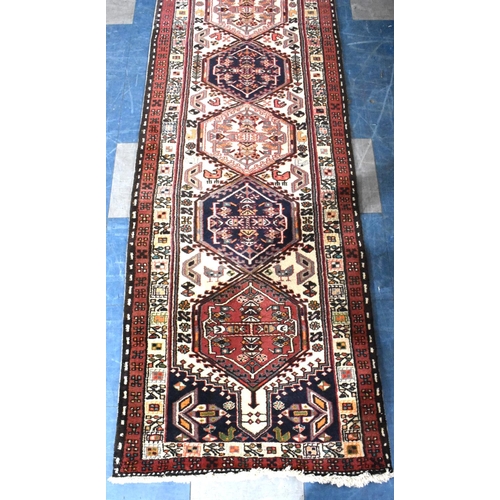 483 - A Persian Patterned Woollen Runner, 290x74cms