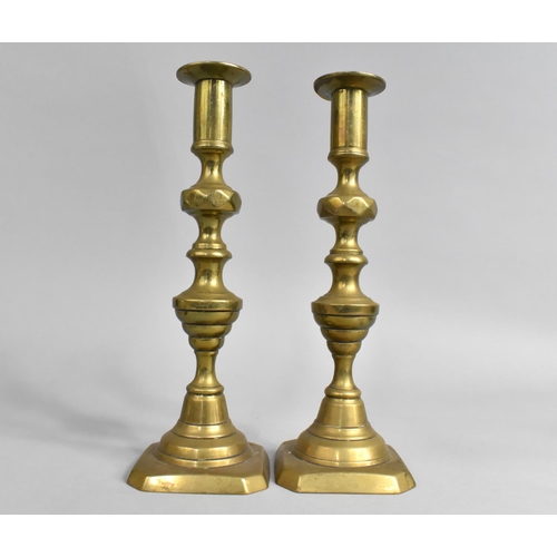 57 - A Pair of Late Victorian Brass Candlesticks with Pushers, 27cms High