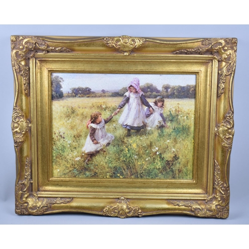 130 - A Reproduction Gilt Framed Print Depicting Children Playing in Meadow, 39x29cms