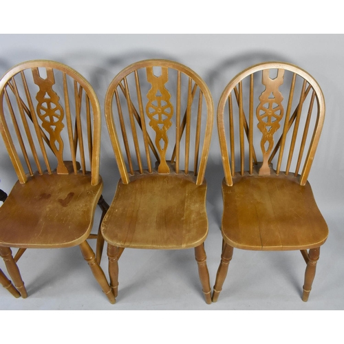 517 - A Set of Four Wheel Back Dining Chairs