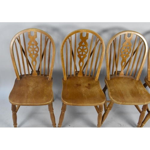 517 - A Set of Four Wheel Back Dining Chairs