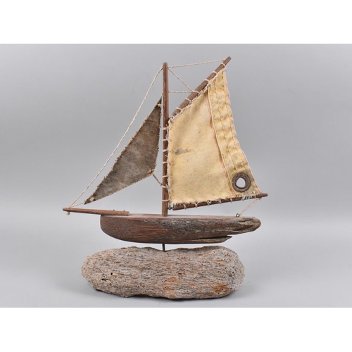 128 - A Wooden Model of a Boat on Driftwood Base, 36cms High