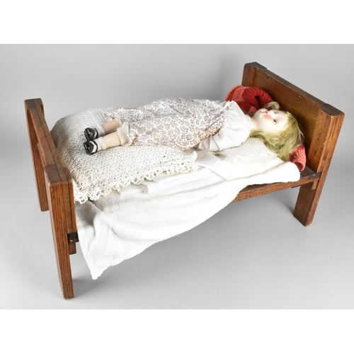 229 - A Mid 20th Century Wooden Dolls Bed Complete with Ceramic Faced Doll, Bed 59x30cms High