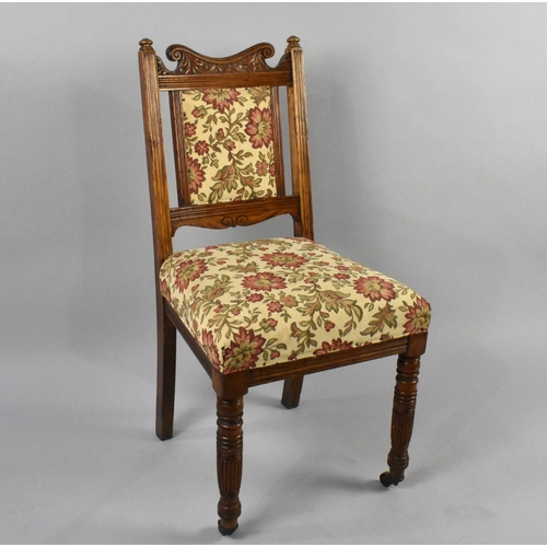 554 - An Early 20th Century Upholstered Oak Framed Chair with Carved Back on Turned Castor Supports