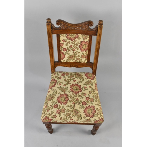 554 - An Early 20th Century Upholstered Oak Framed Chair with Carved Back on Turned Castor Supports