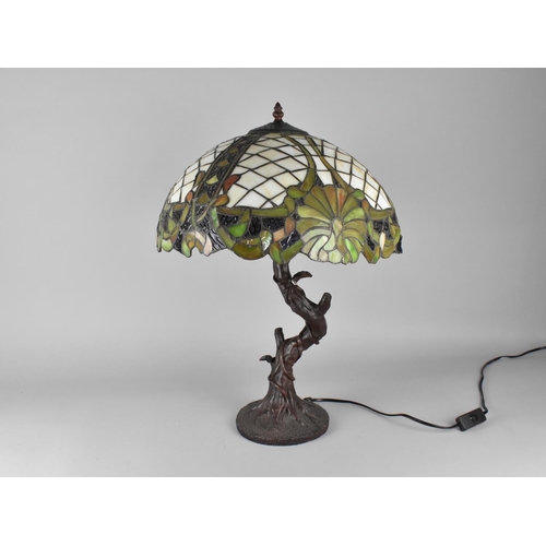 78 - A Tiffany Style Table Lamp with Bronzed Branch Supports (Shade with Some Damage) 57cms High