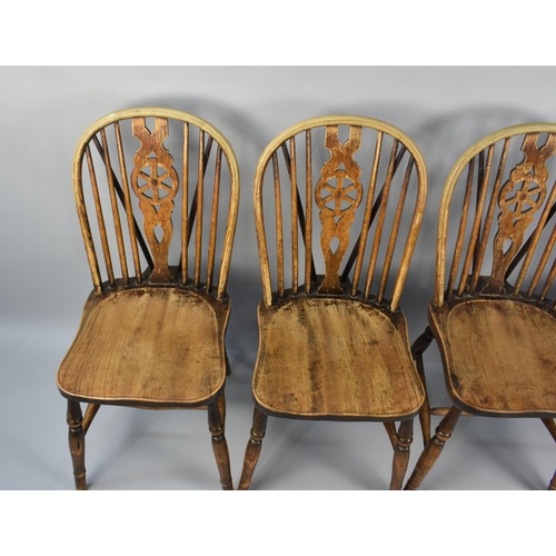 500 - A Set of Four Wheel backed Dining Chairs in Need of Some Restoration