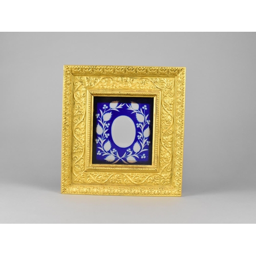 93 - A Gilt Frame of Ornate Stepped Form having Blue Overlaid Glass Panel, 24x25cms